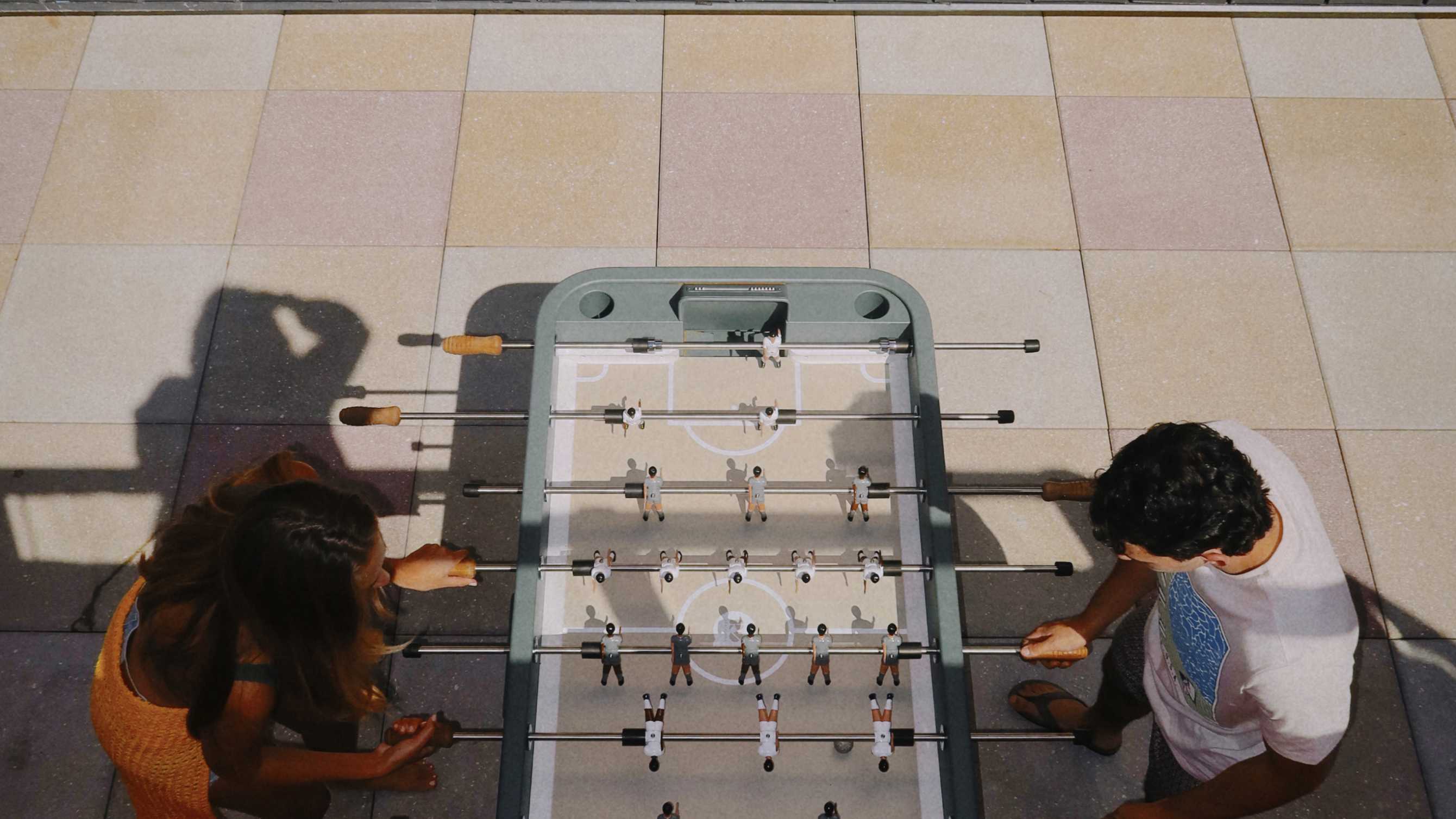 Friends playing at a foosball table