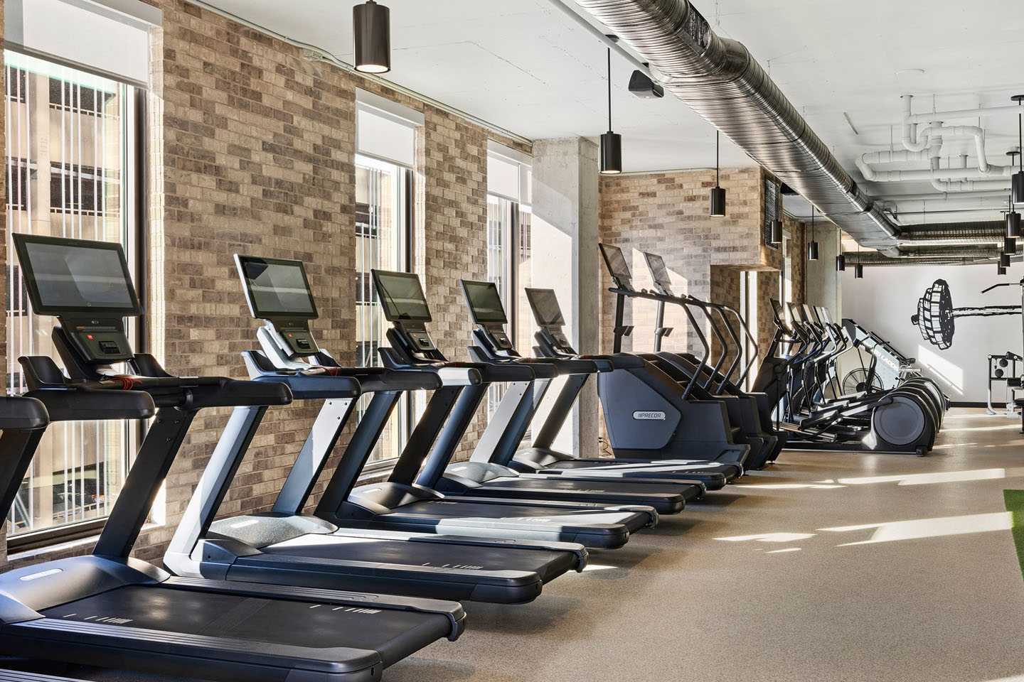 line of treadmills inside an apartment complex gym