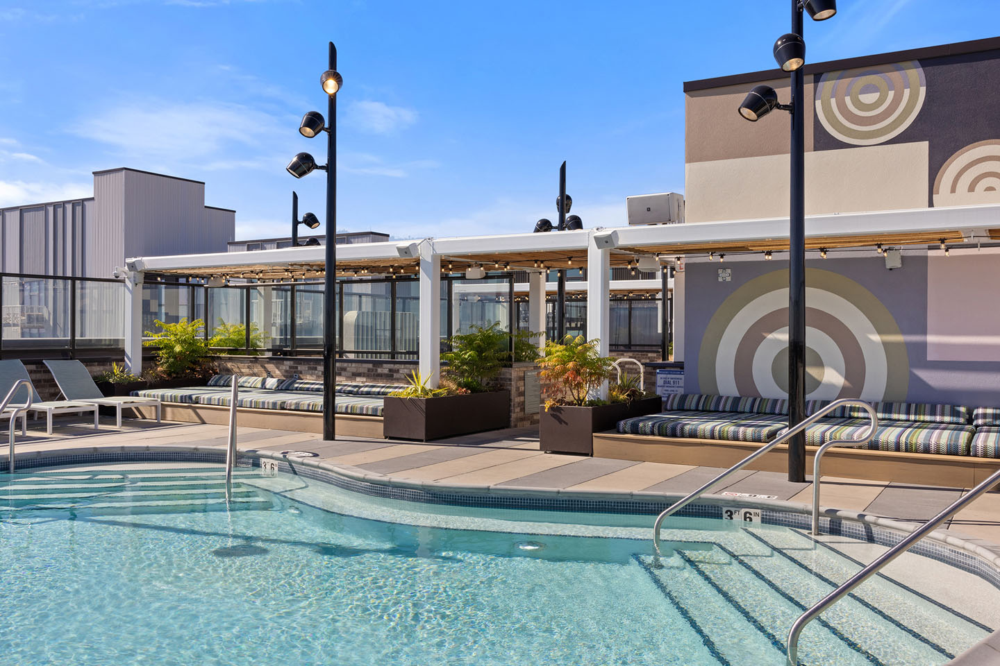 pool with industrial lighting and nearby seating